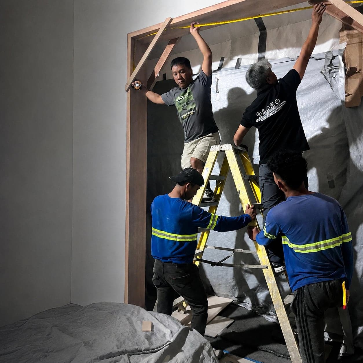 The OLAZO team measuring and fitting a door frame at a project site