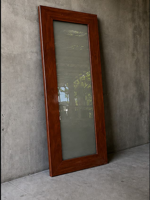 The July-12 door by OLAZO Furniture — a glazed timber door standing against a wall